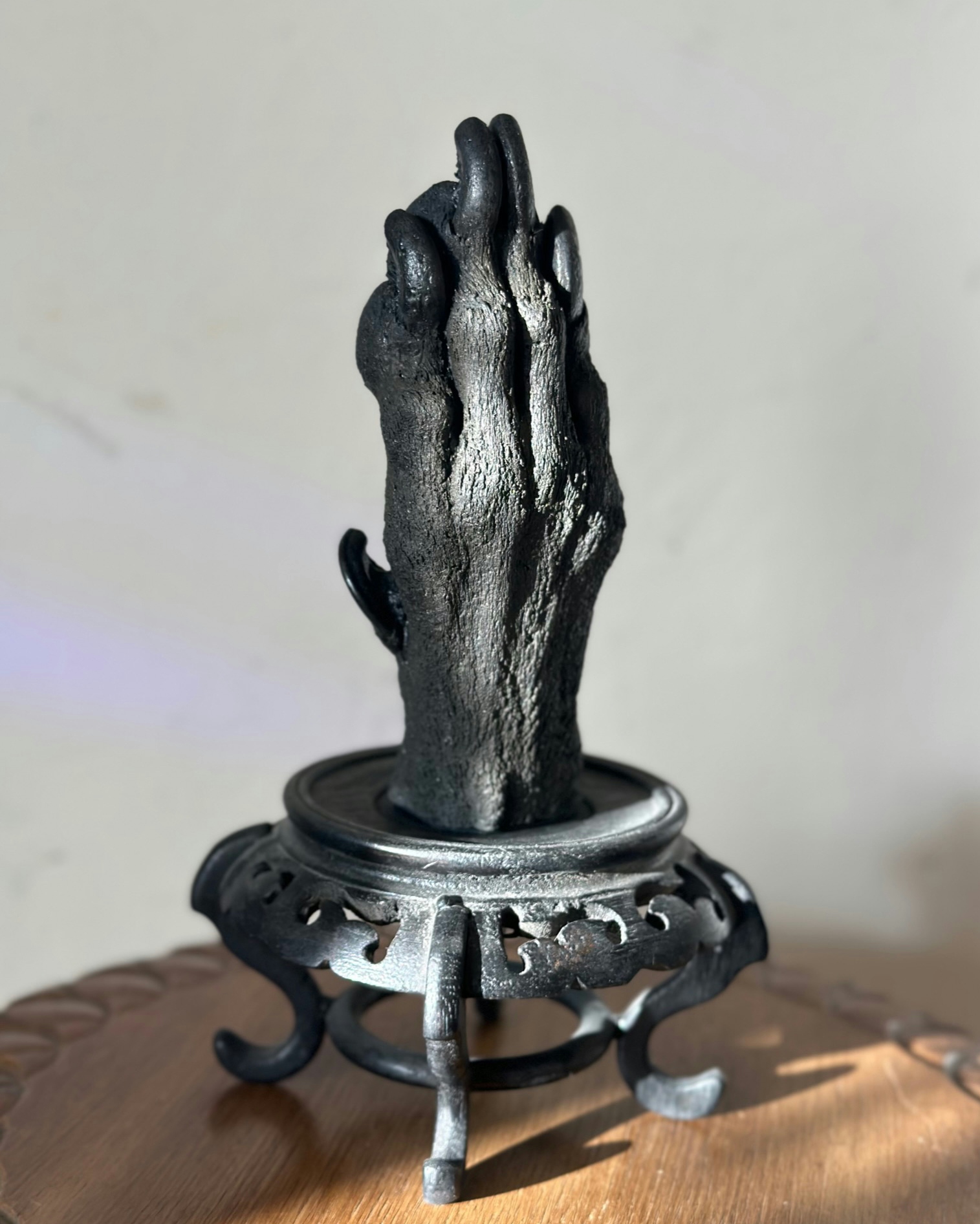 Casts of two large dog paws on a black stand