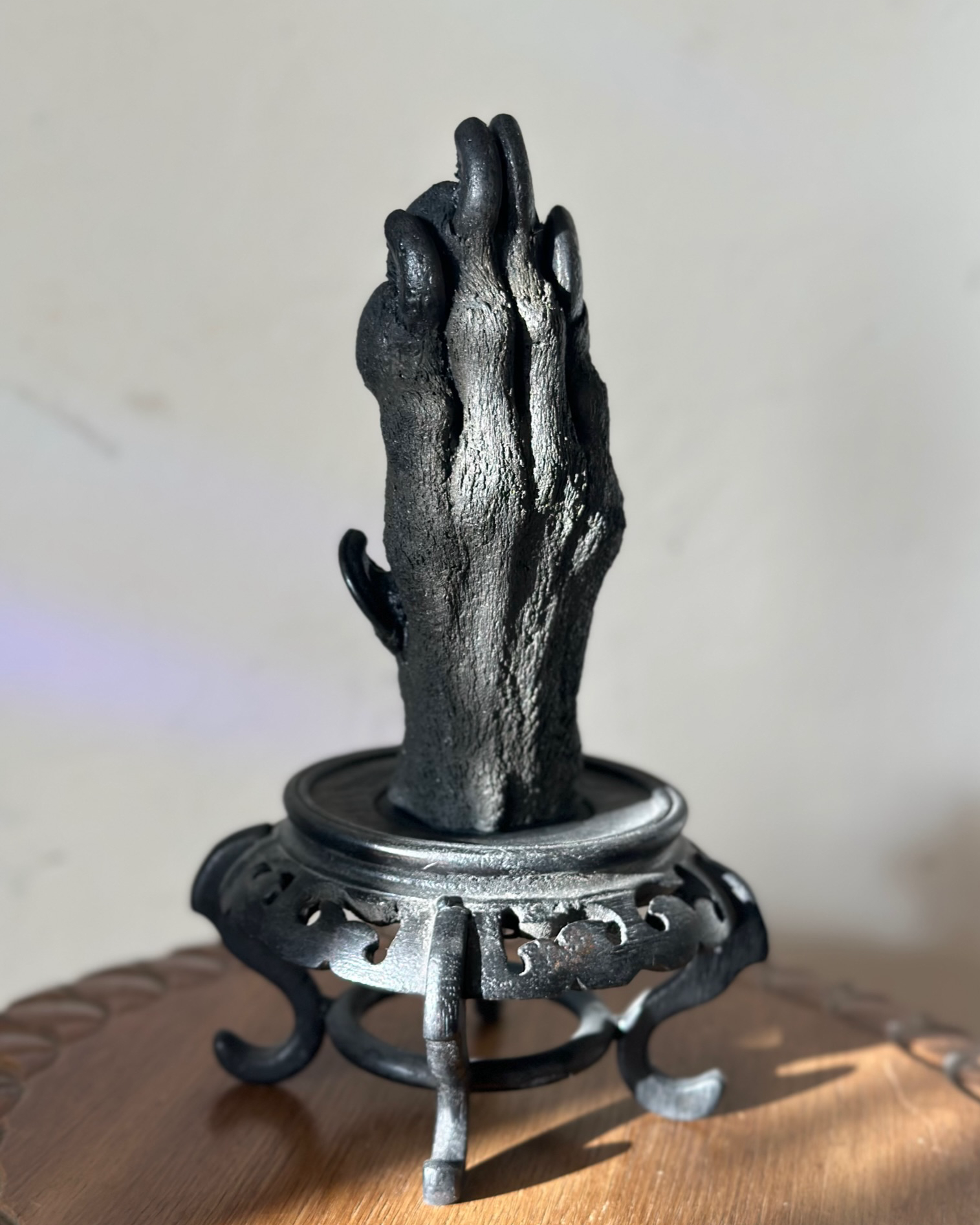 Cast of a large dog paw standing on top of a small plinth